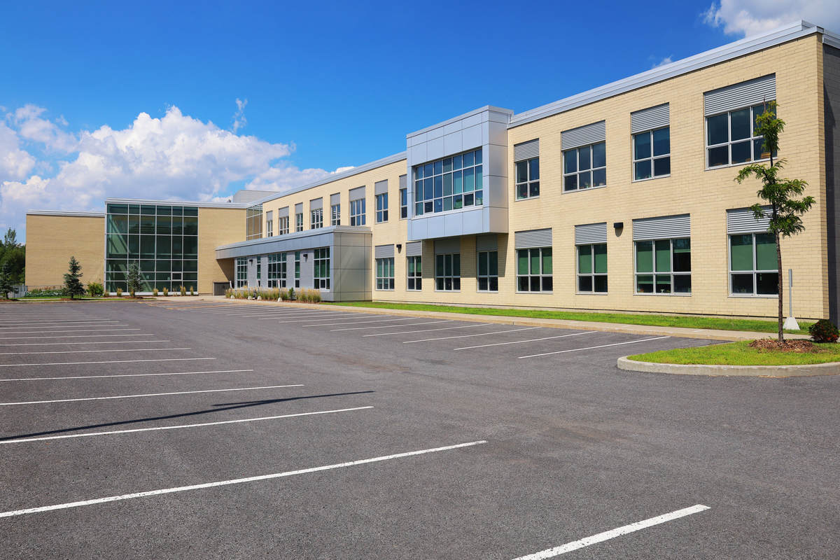 An modern/contemporary elementary, secondary school, college or university building and main entrance, a view from the outside parking lot.